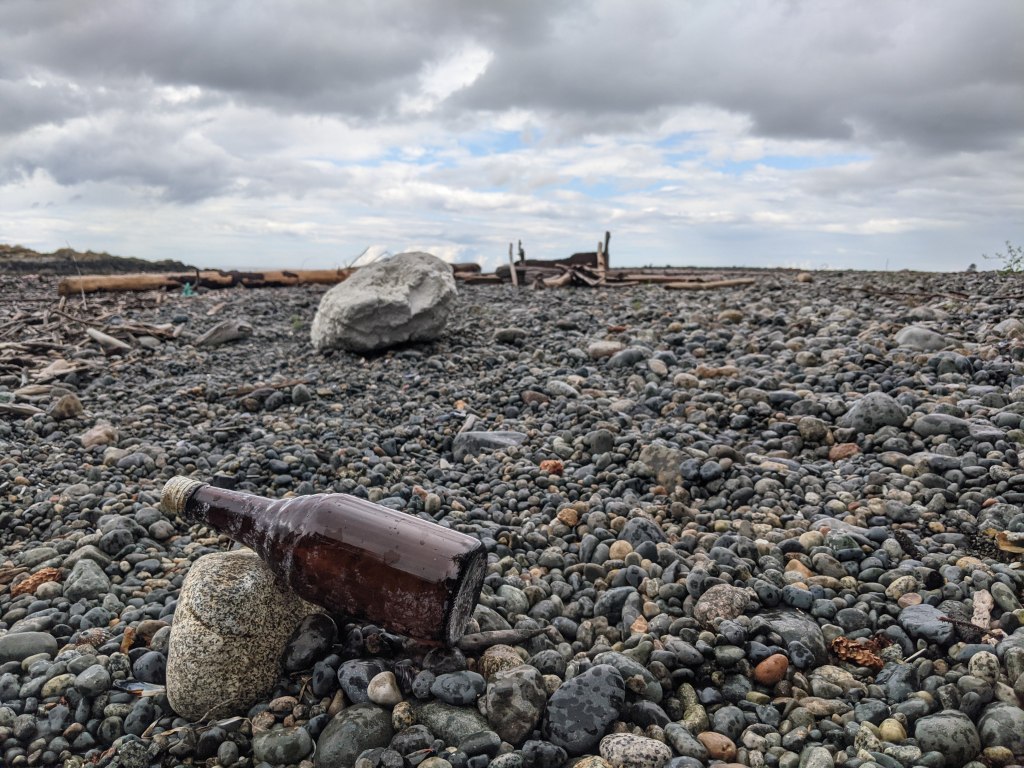 Bottle laying on its side on a rock beach