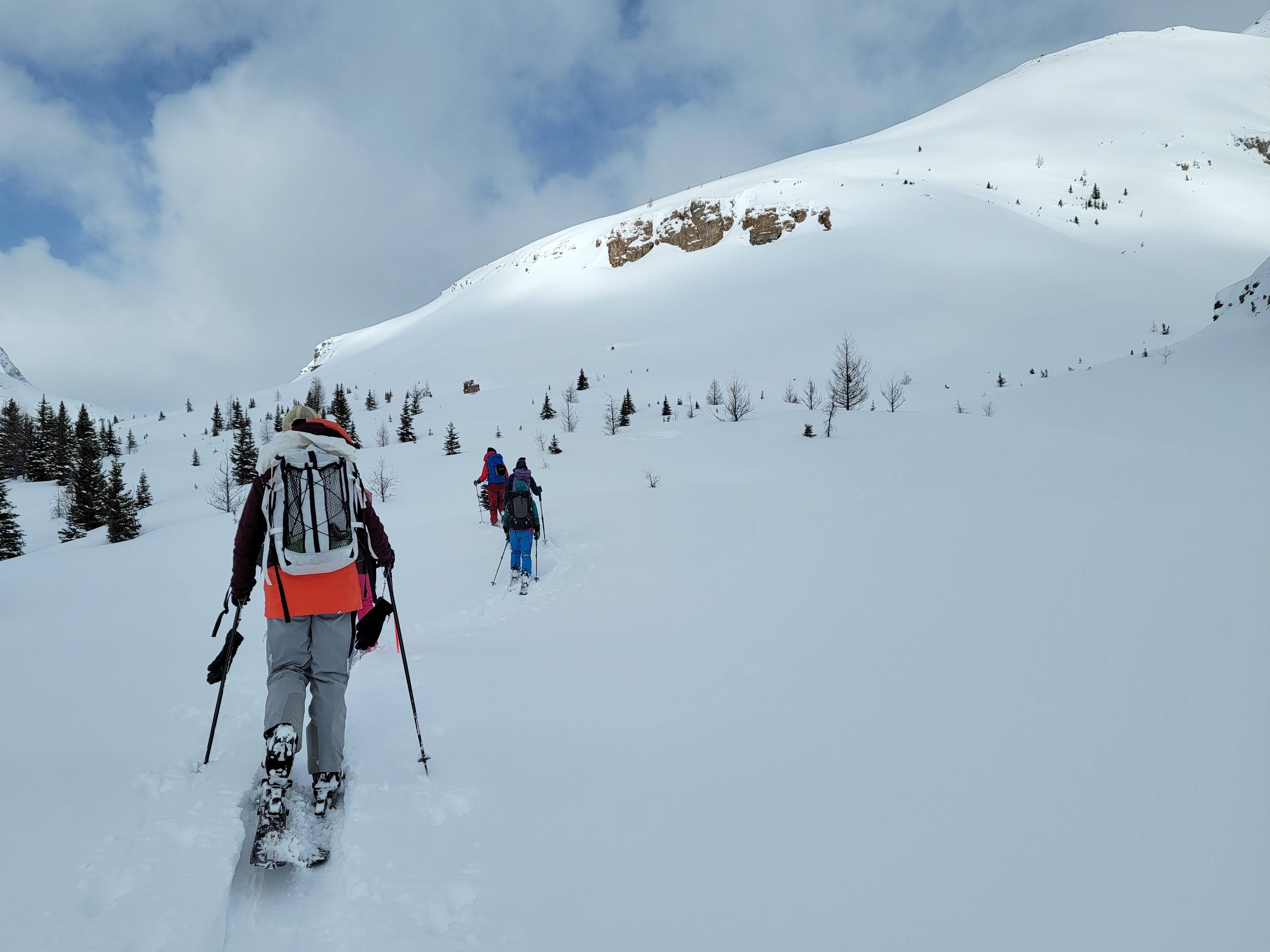 Picture of woman wearing a Hyperlite Mountain Gear Porter 3400 backpack with stuff pocket, skinning up a snowy slope.